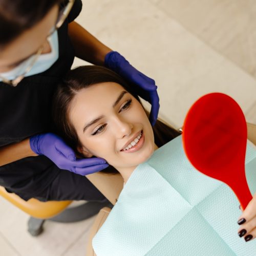 The dentist checks the patient's condition by touching her head